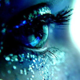 closeup of a single eye lined with blue glitter